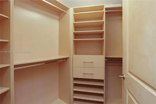 a view of walk in closet with empty racks