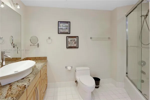 a bathroom with a granite countertop toilet sink and shower