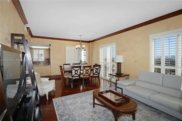 a living room with furniture a table and wooden floor