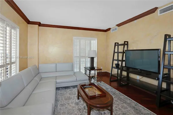 a living room with furniture a flat screen tv and a window