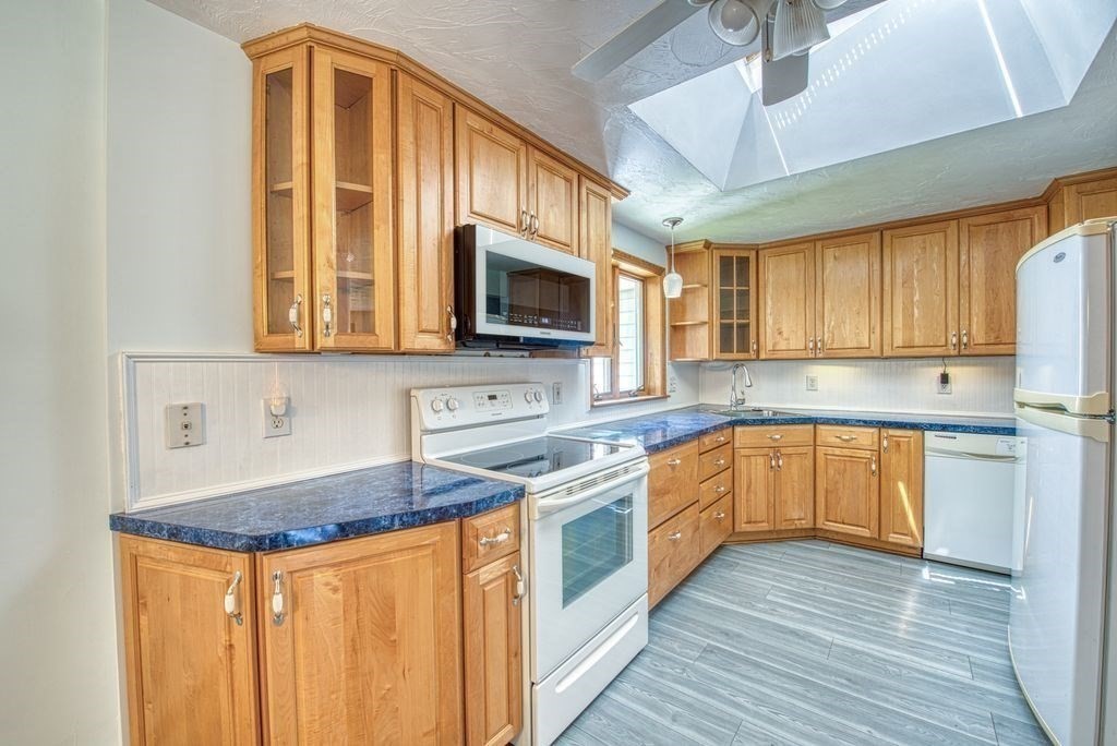 81 Errol Road Brockton, MA 02302 - Photo 19 of 31 a kitchen with stainless steel appliances granite countertop wooden cabinets a stove top oven a sink and dishwasher with wooden floor