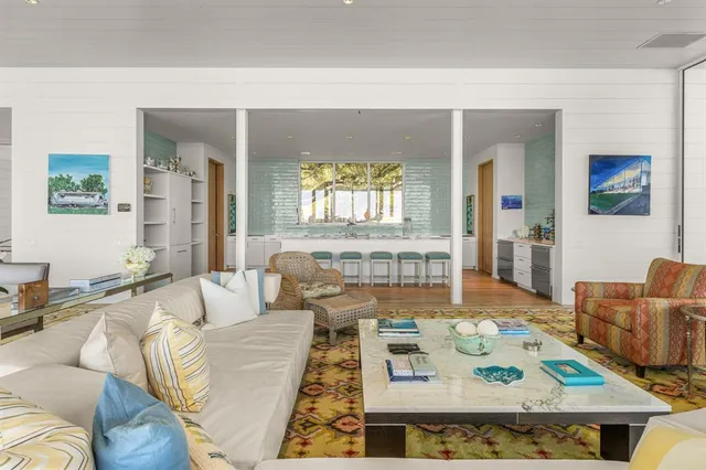 a large kitchen with kitchen island granite countertop a stove a sink a dining table and chairs