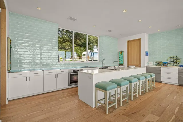 a large kitchen with stainless steel appliances granite countertop a sink and cabinets