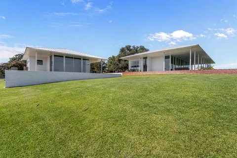 a view of a chair and tables in the back yard of the house