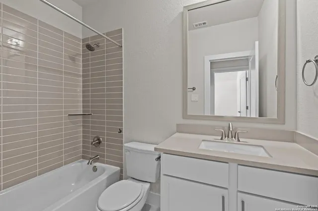 a bathroom with a granite countertop toilet sink shower and mirror
