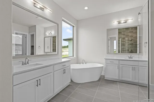 a spacious bathroom with a double vanity sink mirror and bathtub