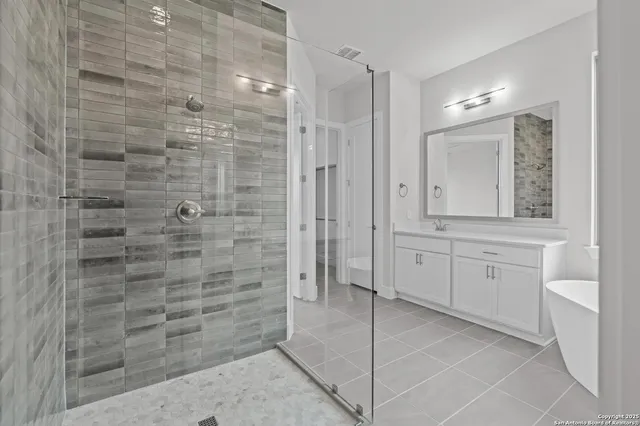 a bathroom with a granite countertop sink a mirror and shower