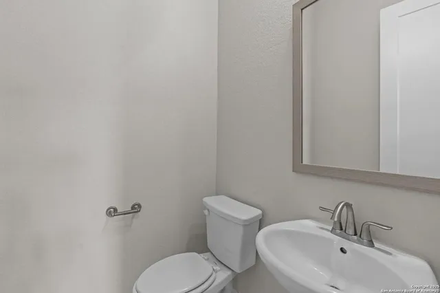 a bathroom with a toilet sink and mirror