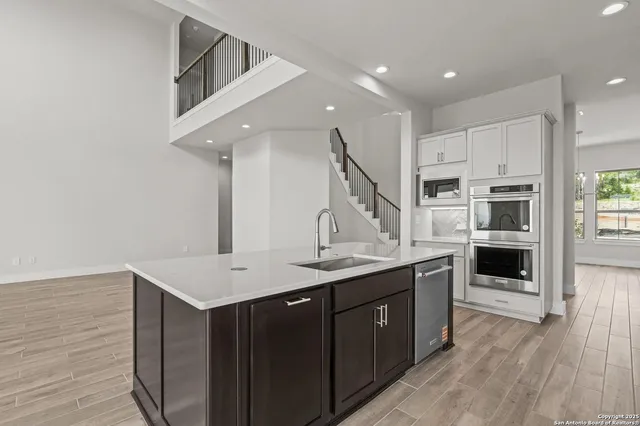 a kitchen with stainless steel appliances kitchen island a cabinets and wooden floor