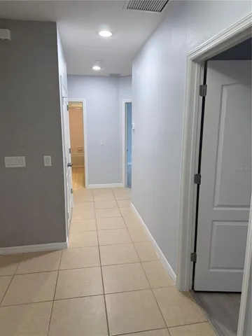a view of hallway with a window and livingroom