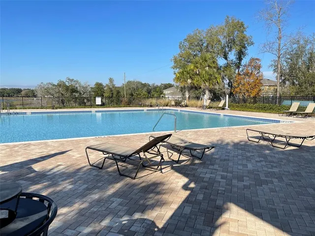 a view of swimming pool outdoor seating and lake view