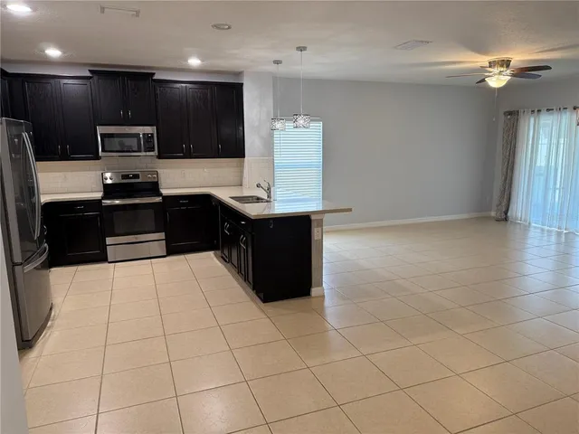 a kitchen with stainless steel appliances a sink a stove a refrigerator and cabinets