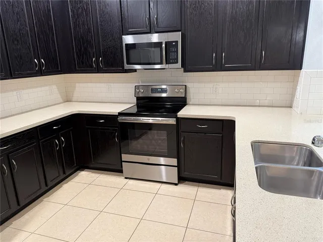 a kitchen with a sink and a stove top oven