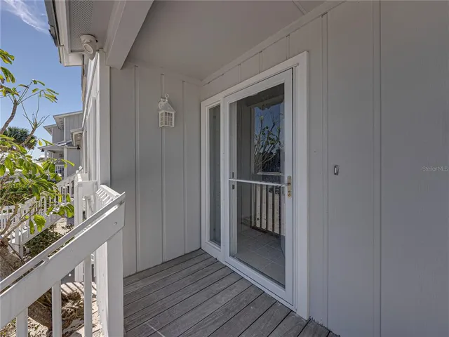 a view of a hallway with wooden floor and a potted plant