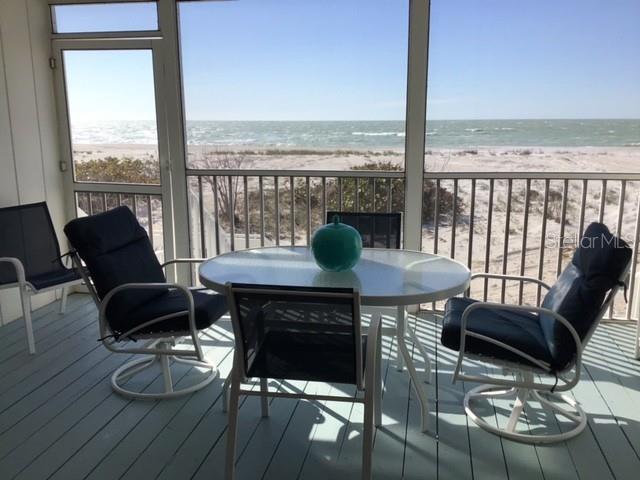 420 Gulf Boulevard, Unit 6 Boca Grande, FL 33921 - Photo 4 of 26 a living room with furniture and floor to ceiling windows