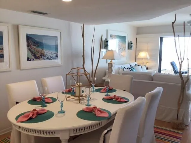 a view of a dining room with furniture on the table and a kitchen