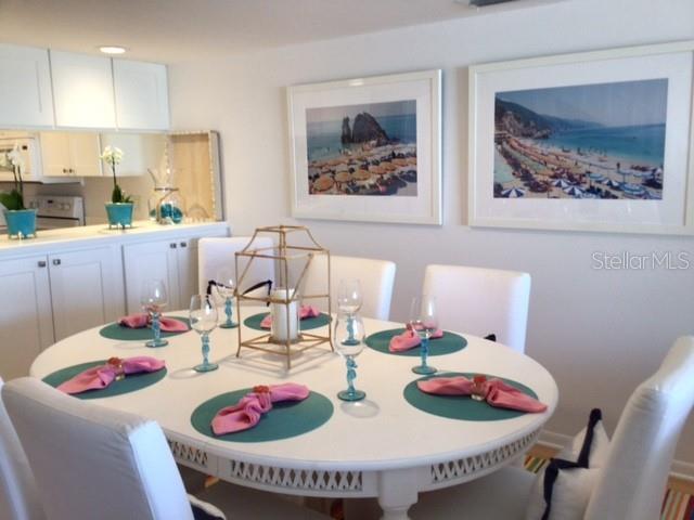 420 Gulf Boulevard, Unit 6 Boca Grande, FL 33921 - Photo 9 of 26 a view of a dining room with furniture on the table and a kitchen