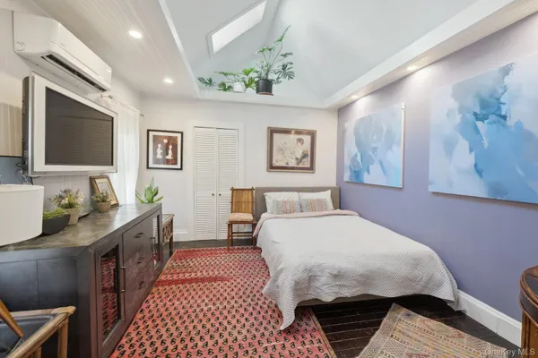 a spacious bedroom with a bed and wooden floor