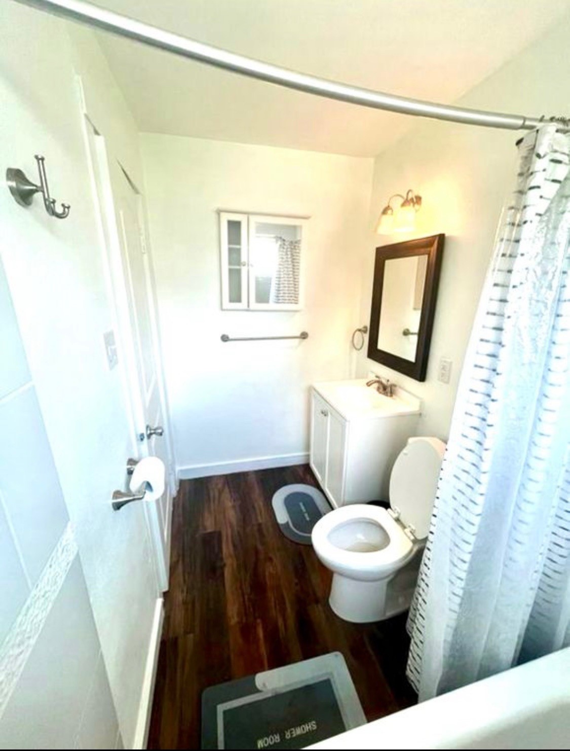 2117 Everett Street, Unit B Houston, TX 77009 - Photo 5 of 7 a white toilet sitting next to a bathroom sink and a mirror