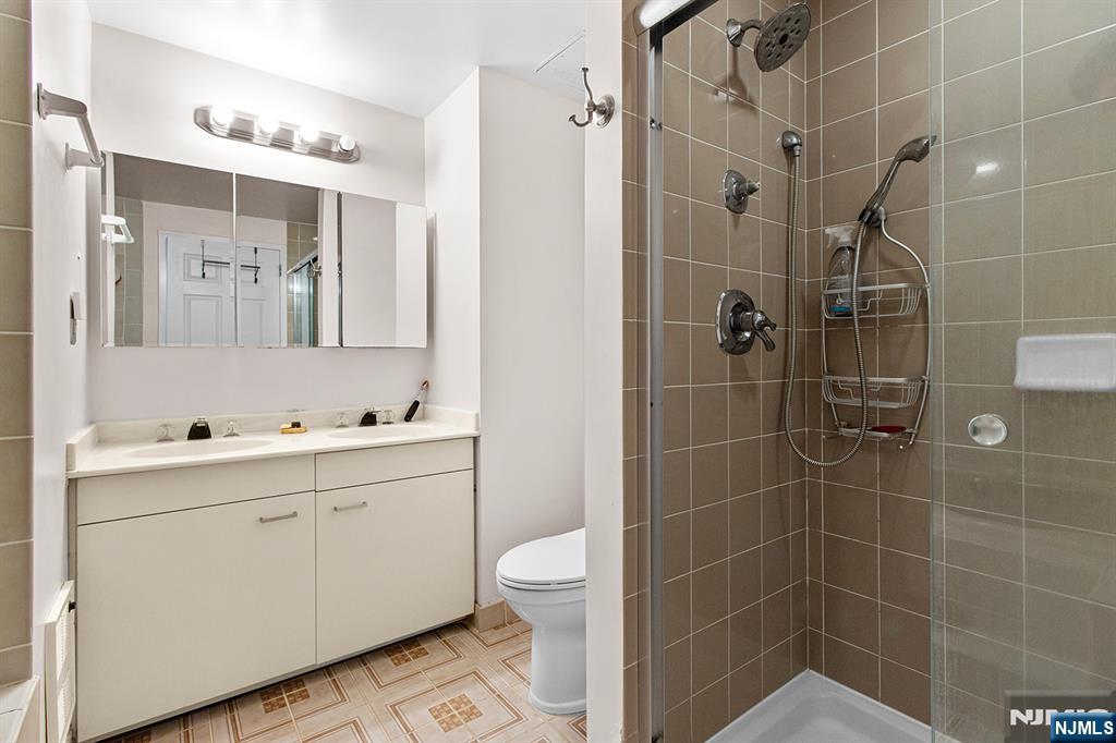 800 Palisade Avenue, Unit 2007 Fort Lee, NJ 07024 - Photo 17 of 21 a bathroom with a double vanity sink toilet and shower