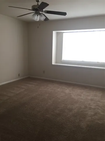 en empty room with windows and fan