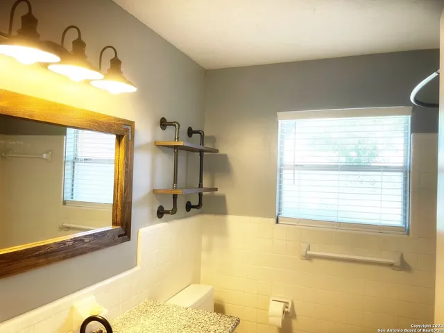 a bathroom with a tub sink and mirror