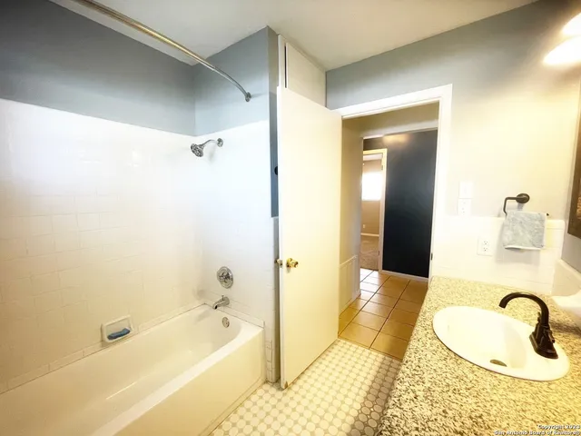 a bathroom with a tub a sink and a shower