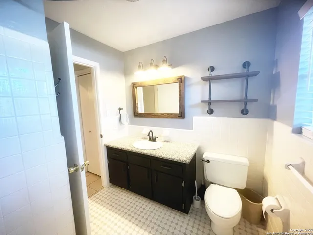 a bathroom with a toilet sink and mirror
