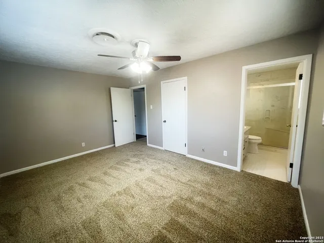 an empty room with a bathroom and a shower