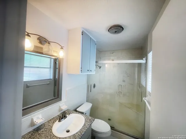 a bathroom with a toilet a sink and shower