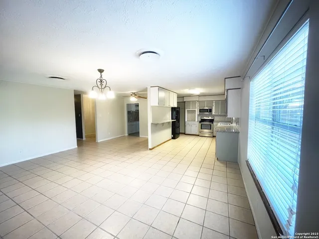 a view of a kitchen with furniture and a refrigerator