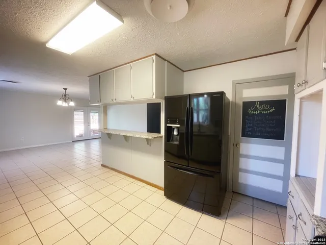 a kitchen with stainless steel appliances kitchen island granite countertop a refrigerator and a sink