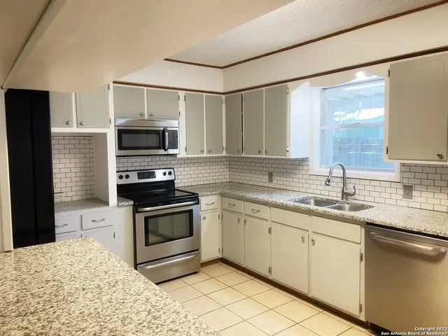 a kitchen with a sink appliances and cabinets
