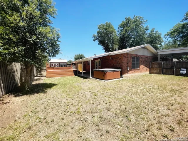 a backyard of a house with yard and tree