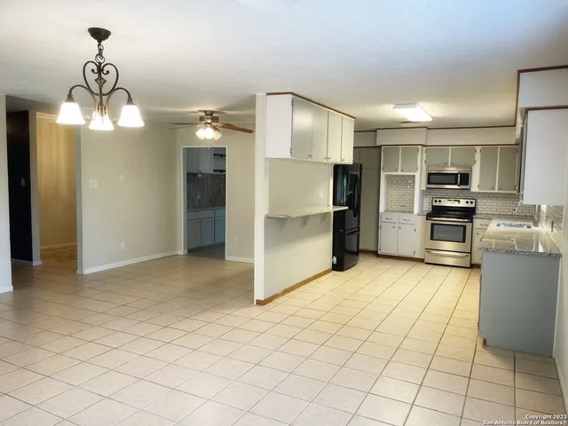 a view of a kitchen with fridge and wooden floor