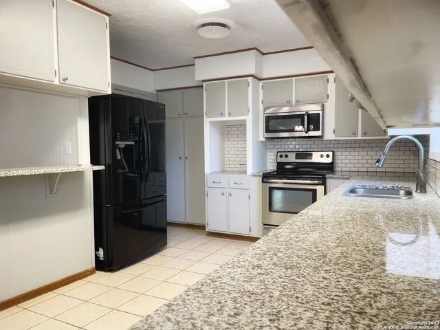 a kitchen with stainless steel appliances granite countertop a refrigerator and a sink
