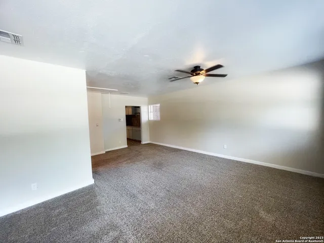 a view of a livingroom with a ceiling fan and window