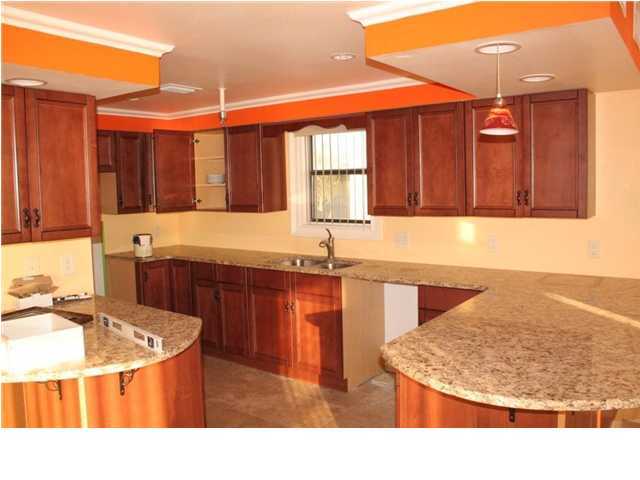 654 Harbor Boulevard, Unit 2 Destin, FL 32541 - Photo 4 of 14 a kitchen with stainless steel appliances kitchen island granite countertop a sink and a white cabinets