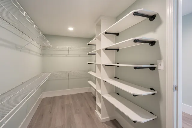 a kitchen with stainless steel appliances granite countertop a dining table chairs and white cabinets