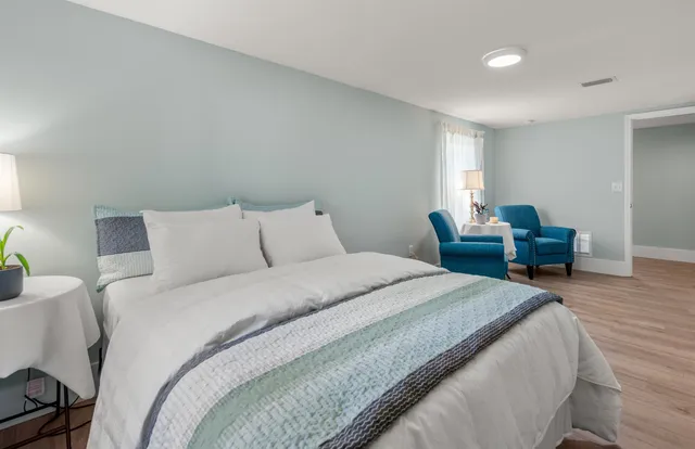 a large white kitchen with kitchen island a sink stainless steel appliances and cabinets