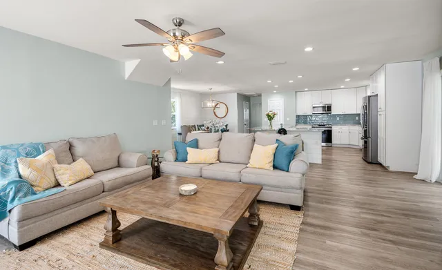 a view of a room with wooden floor and ceiling fan
