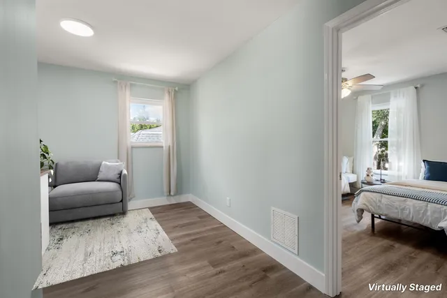 a bathroom with a toilet a sink a mirror a window and vanity