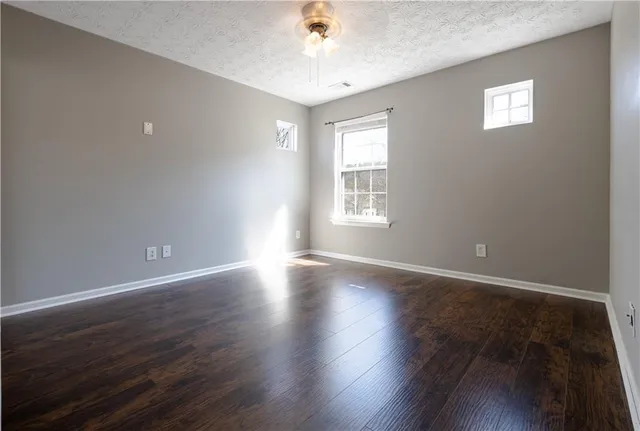 a view of a white house with a yard and potted plants