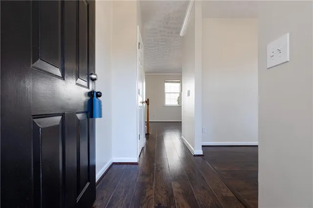 an empty room with wooden floor cabinet and windows