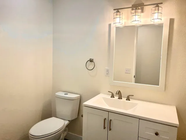 a bathroom with a sink a toilet and mirror