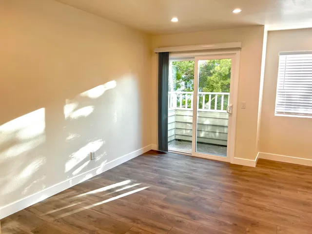 a view of a livingroom with wooden floor and a window
