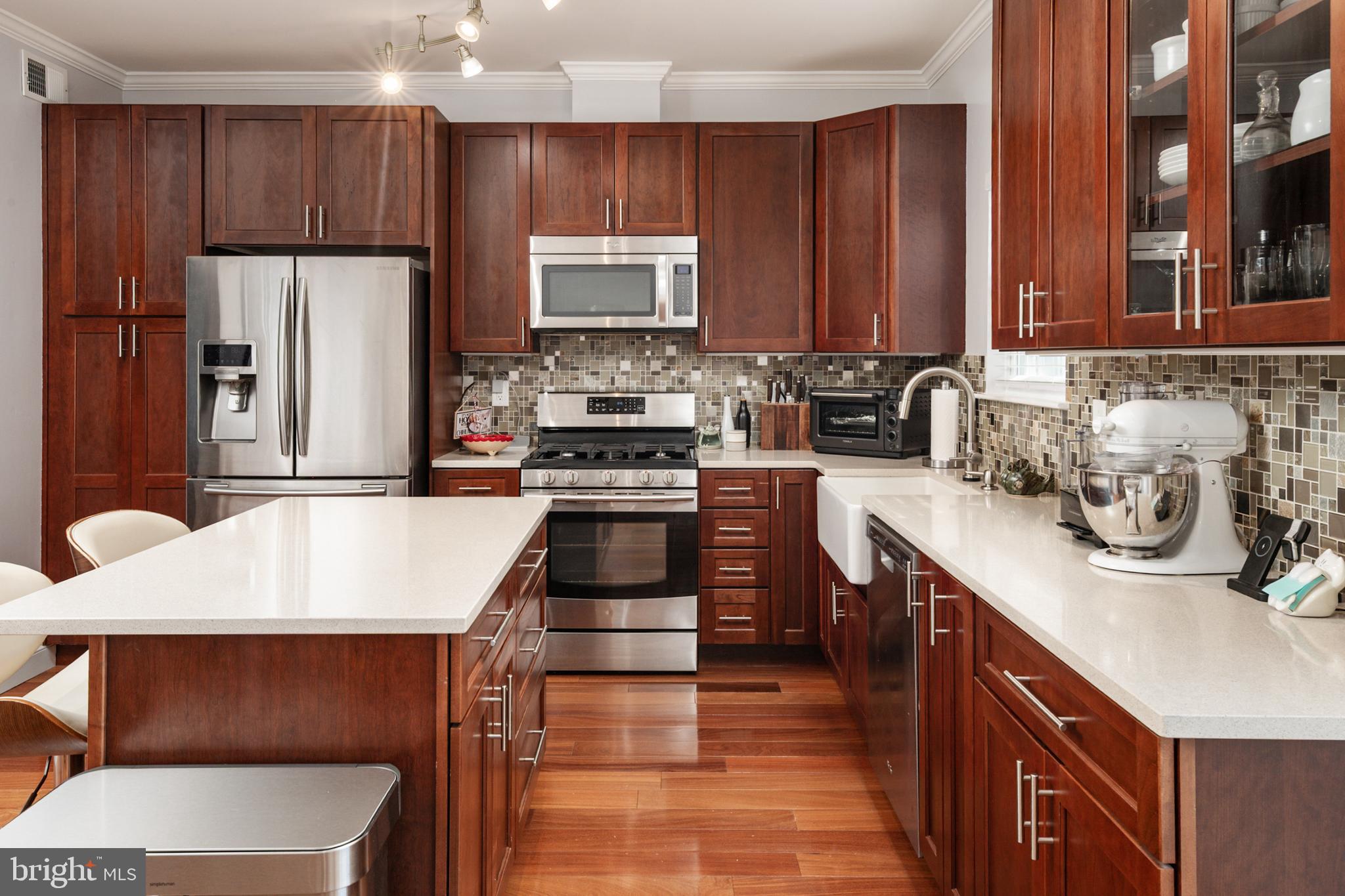 2333 Manomet Court Crofton, MD 21114 - Photo 11 of 44 a kitchen with stainless steel appliances a sink a stove a refrigerator cabinets and a center island