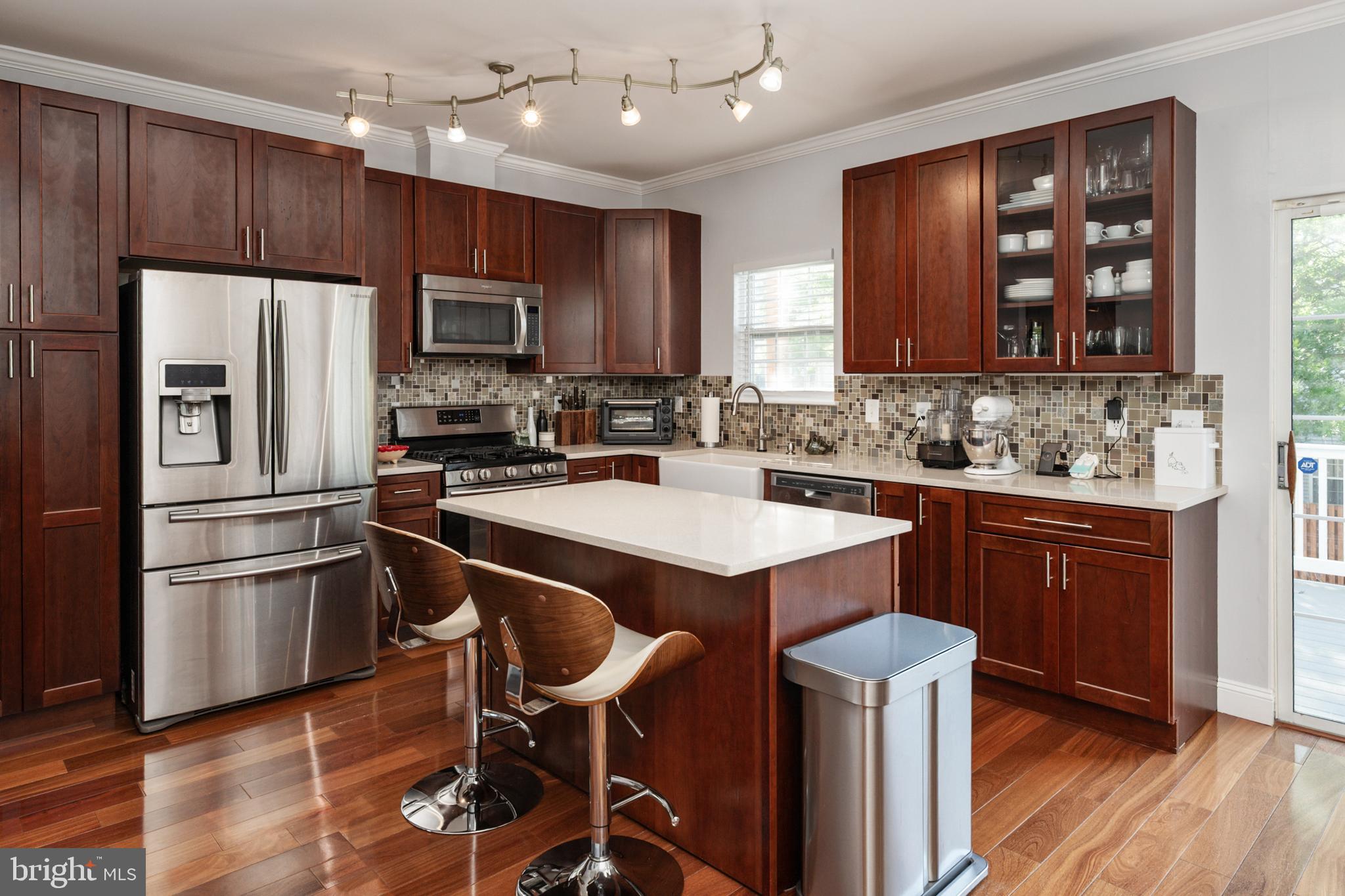 2333 Manomet Court Crofton, MD 21114 - Photo 10 of 44 a kitchen with kitchen island stainless steel appliances a sink cabinets and wooden floor