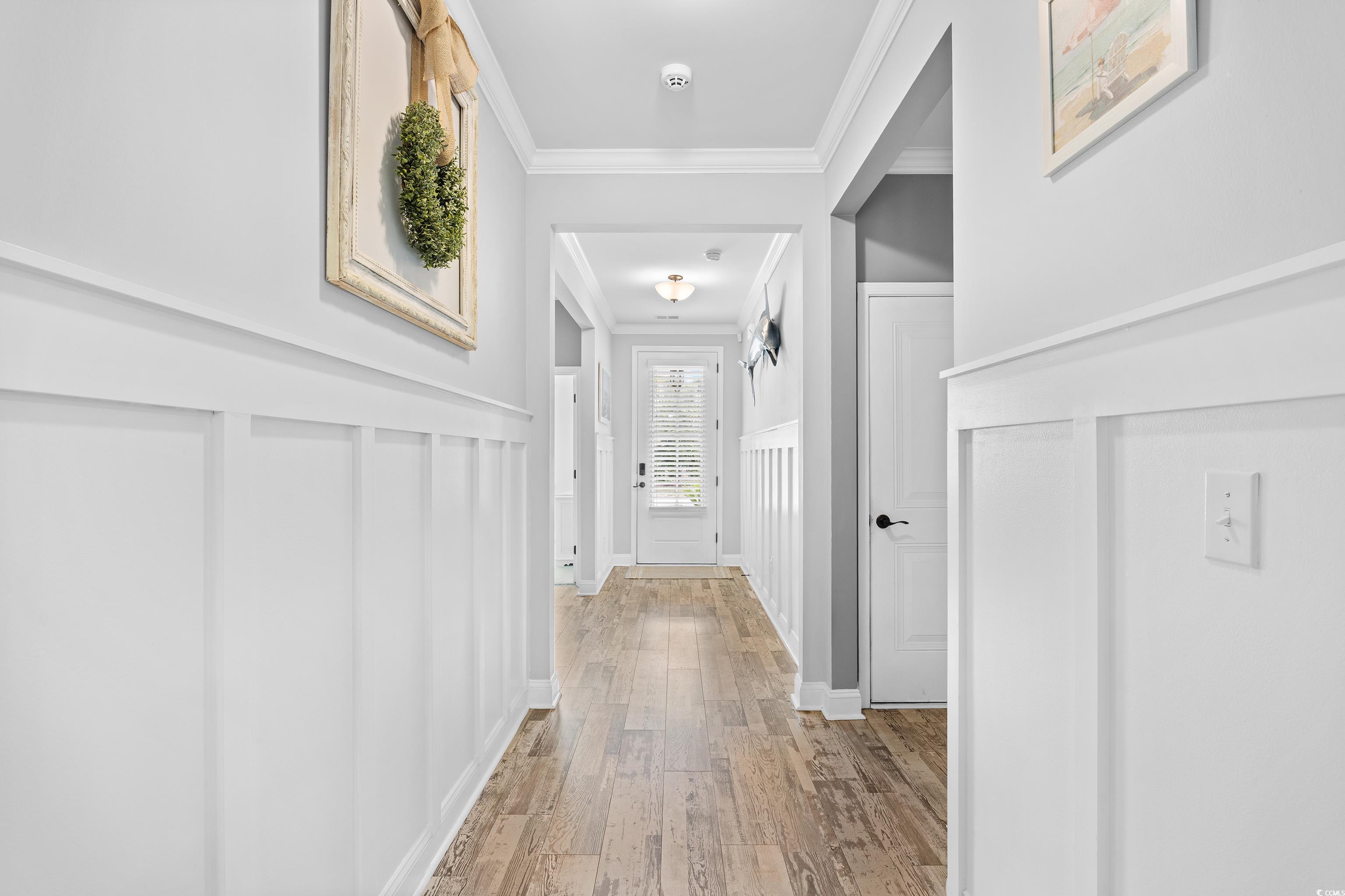 1104 Inlet View Drive North Myrtle Beach, SC 29582 - Photo 13 of 40 Corridor featuring crown molding, hardwood / wood-style flooring, a wainscoted wall, and a decorative wall