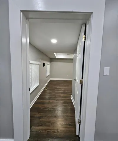a view of a hallway with wooden floor and staircase